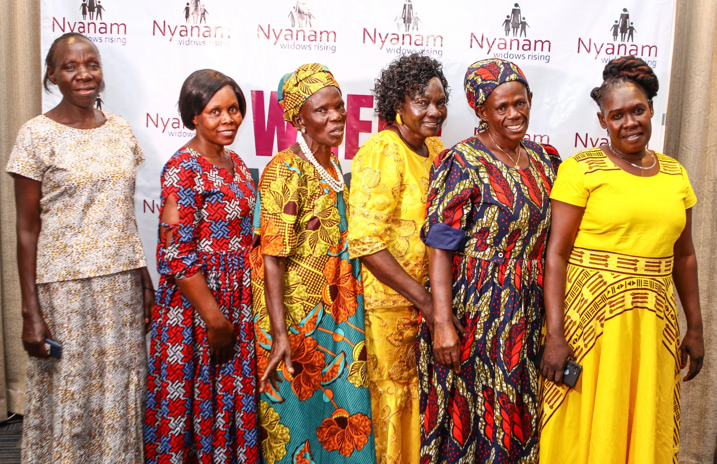 Widows posing in front of the Nyanam backdrop during the 2025 event