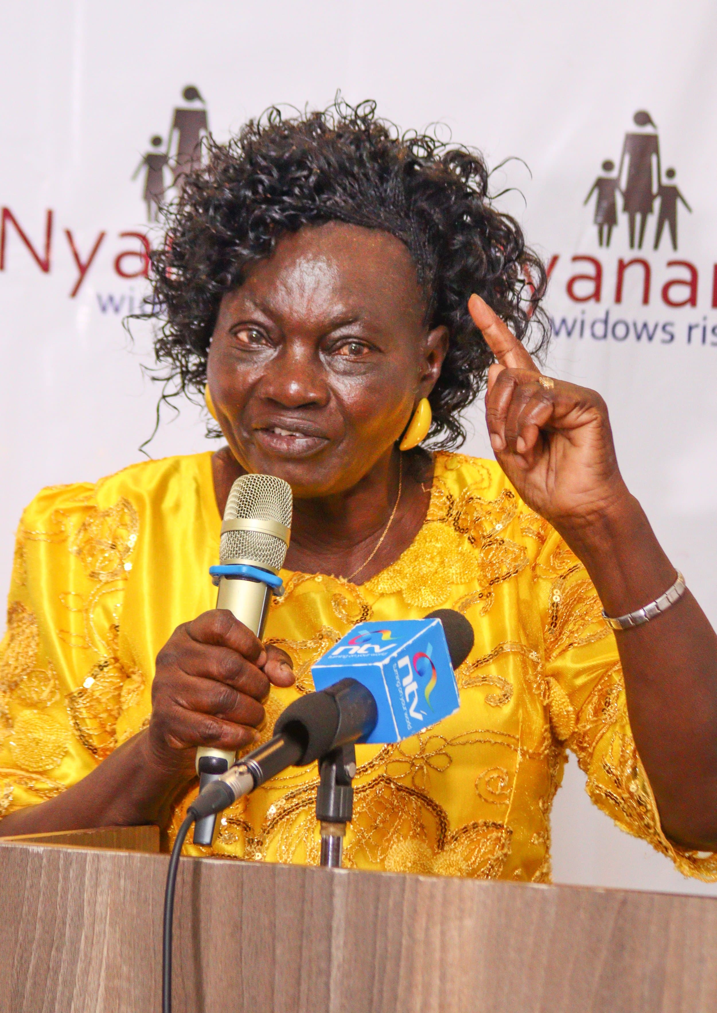 Widow leader speaking during a Nyanam event